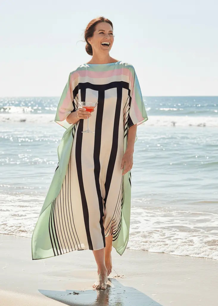 Woman wearing Vicharan Pastel Mist caftan standing on a beach with ocean in the background
